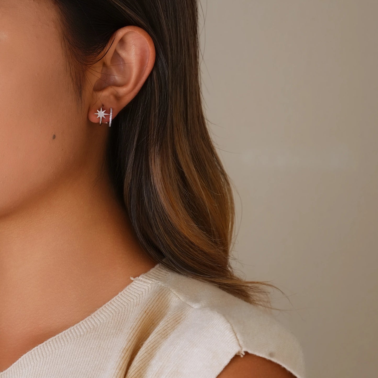 Model wearing silver star clip-on double hoops to show the "pierced" look