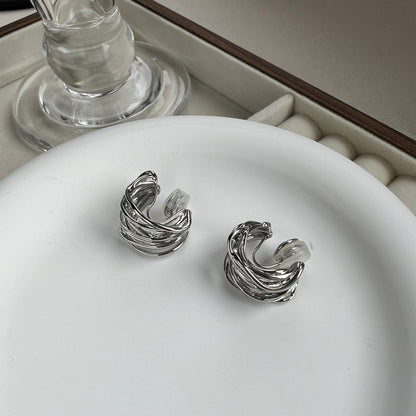 Close-up of silver wide hoop earring showing the pain-free clip-on mechanism for secure and comfortable wear.