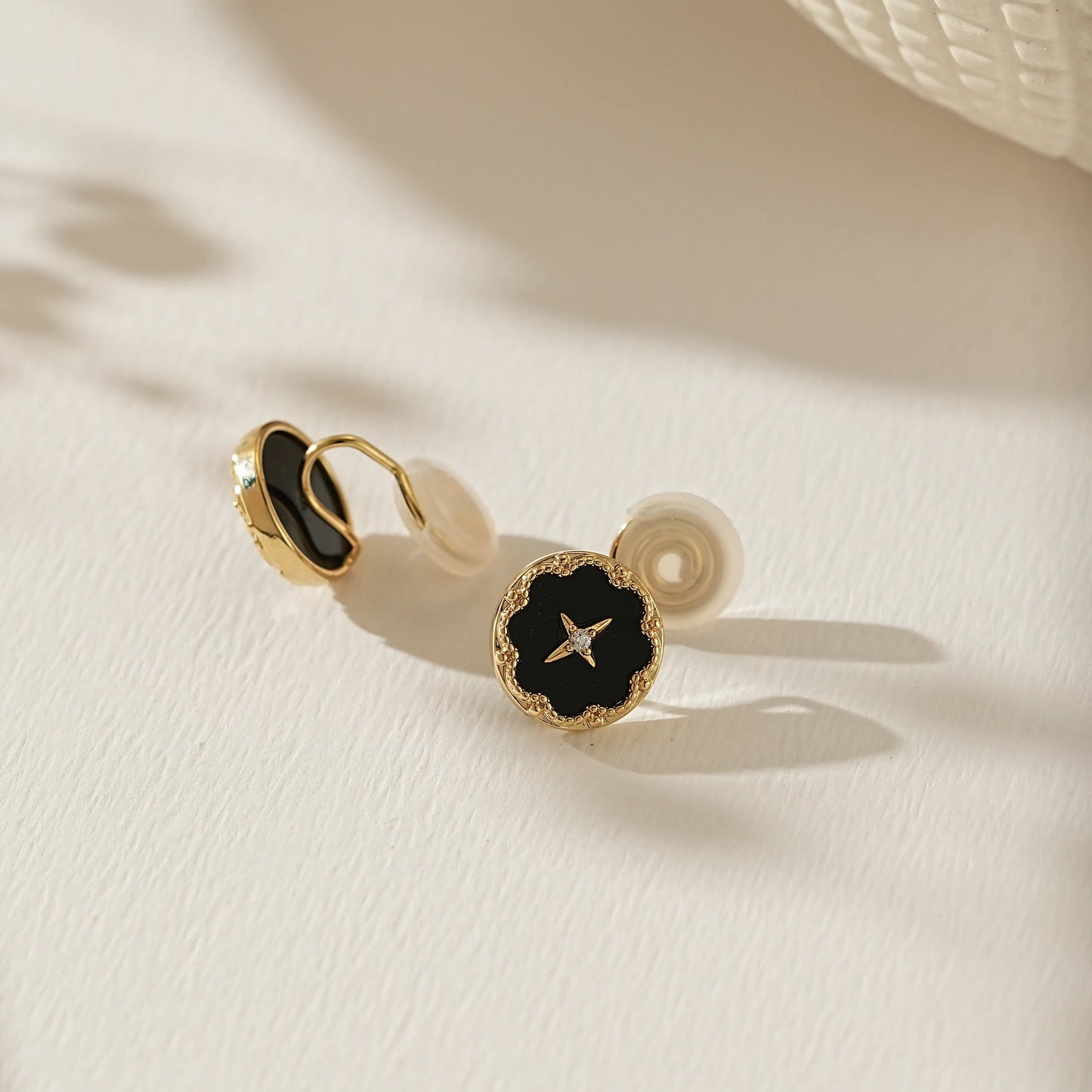 Close-up of the midnight black enamel and 18k gold star detail on celestial studs.