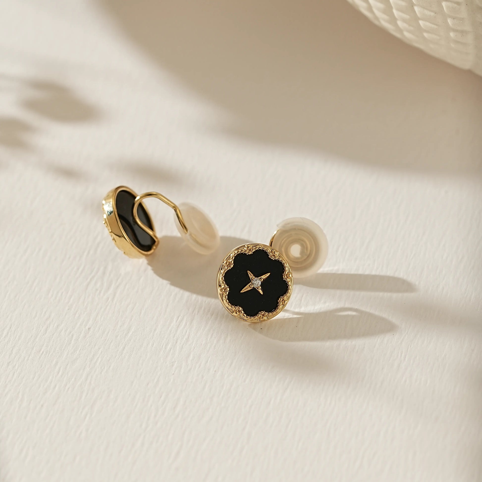 Close-up of the midnight black enamel and 18k gold star detail on celestial studs.