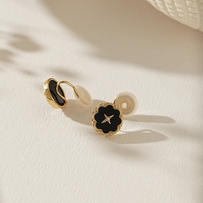 Close-up of the midnight black enamel and 18k gold star detail on celestial studs.
