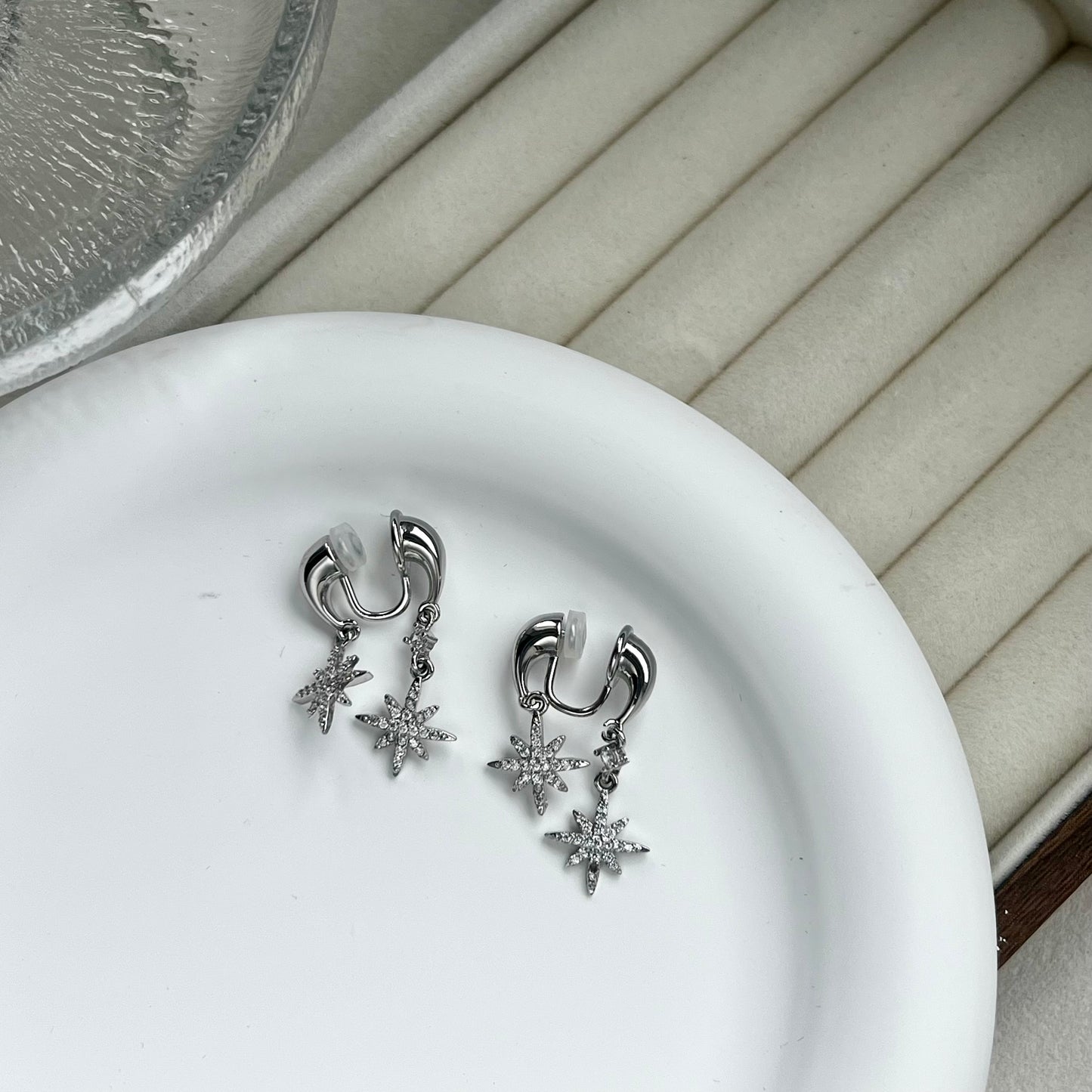 Side profile of a model wearing a silver front-to-back star drop clip-on earring, showing the floating celestial design