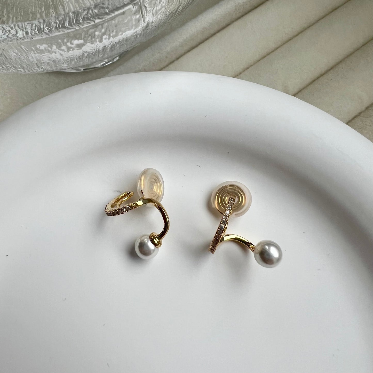Model wearing elegant gold and pearl drop clip-on hoops that look exactly like real pierced earrings.