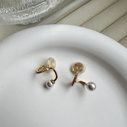 Model wearing elegant gold and pearl drop clip-on hoops that look exactly like real pierced earrings.