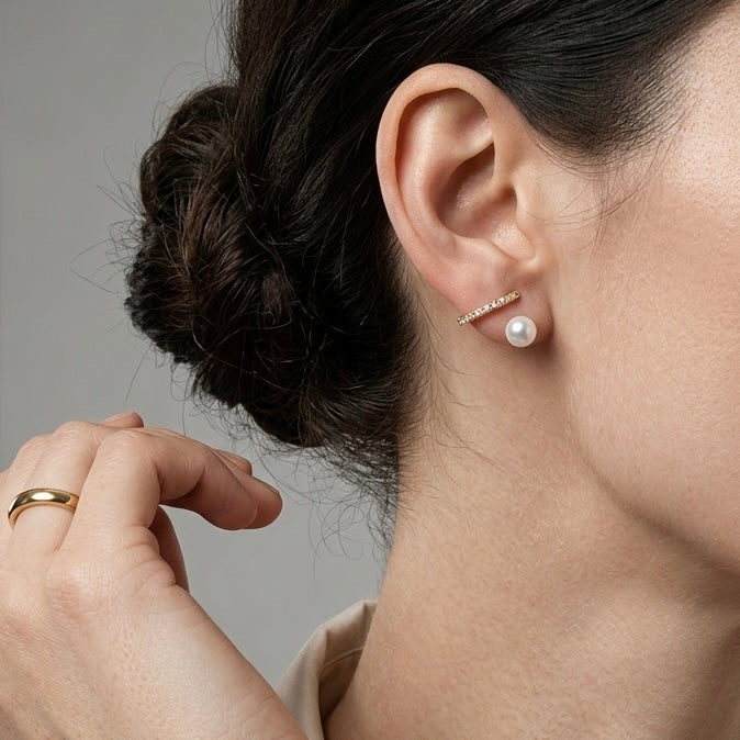 Side profile of a model wearing classic gold and pearl clip-on hoop earrings, showing the seamless and invisible clip mechanism