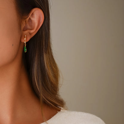 Model wearing emerald dangle diamond clip-on earrings for a glamorous evening look.