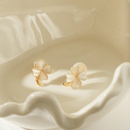 Close-up of the iridescent moonstone inlay on gold four leaf clover clip-ons.