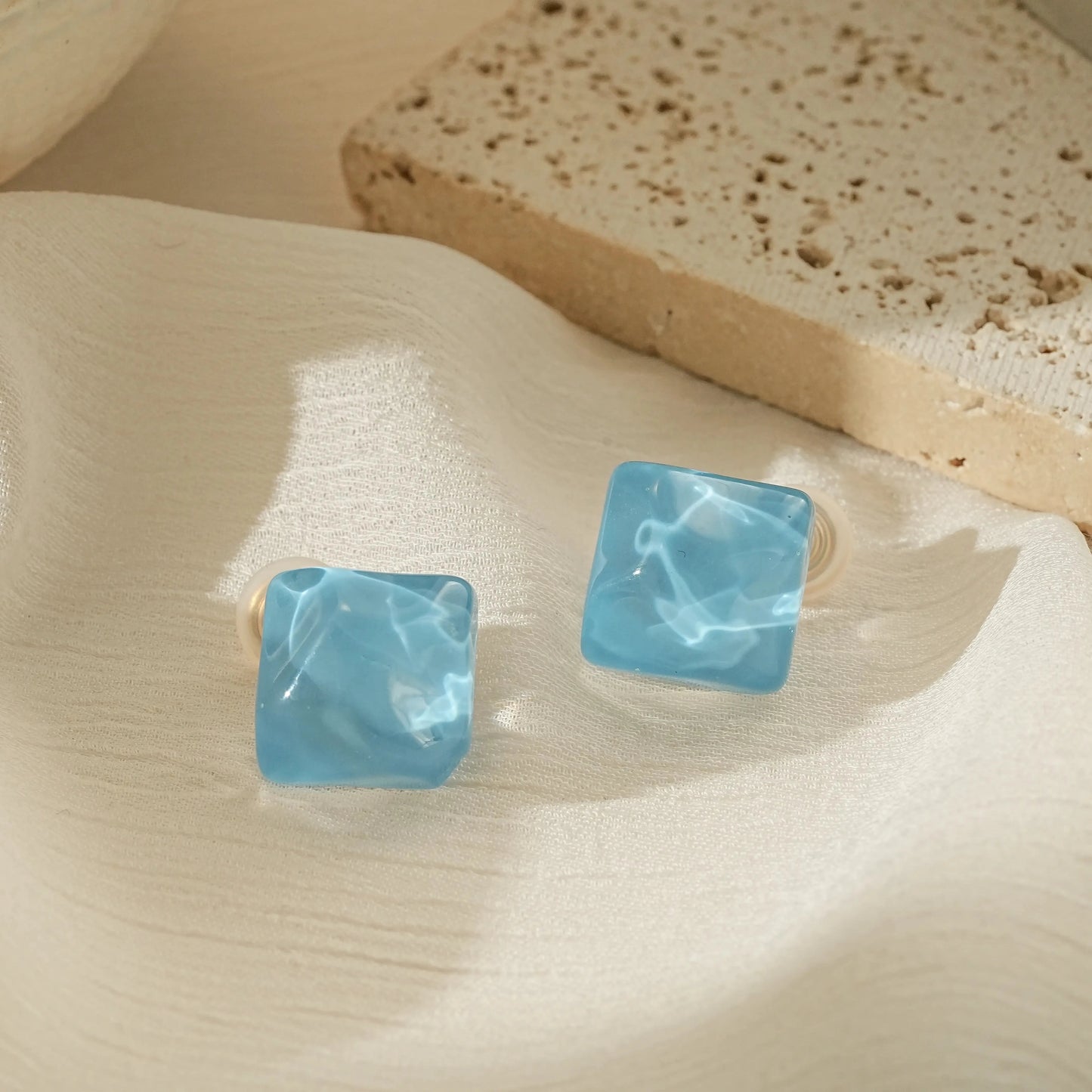 Minimalist ice blue fused glass cube clip-on earrings in a geometric drop design.