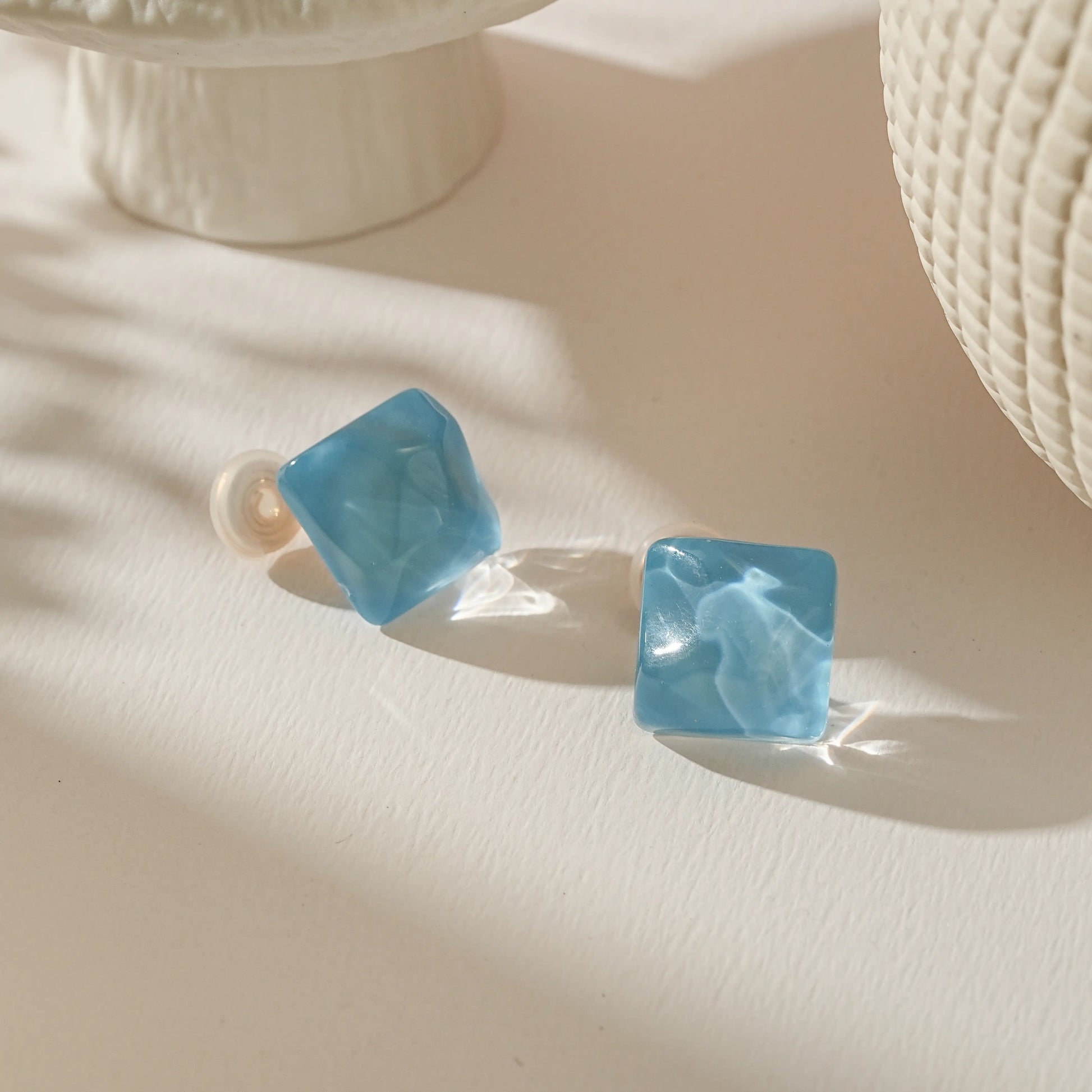 Close-up of the translucent ice blue glass cube, showing the artisan fused glass texture.