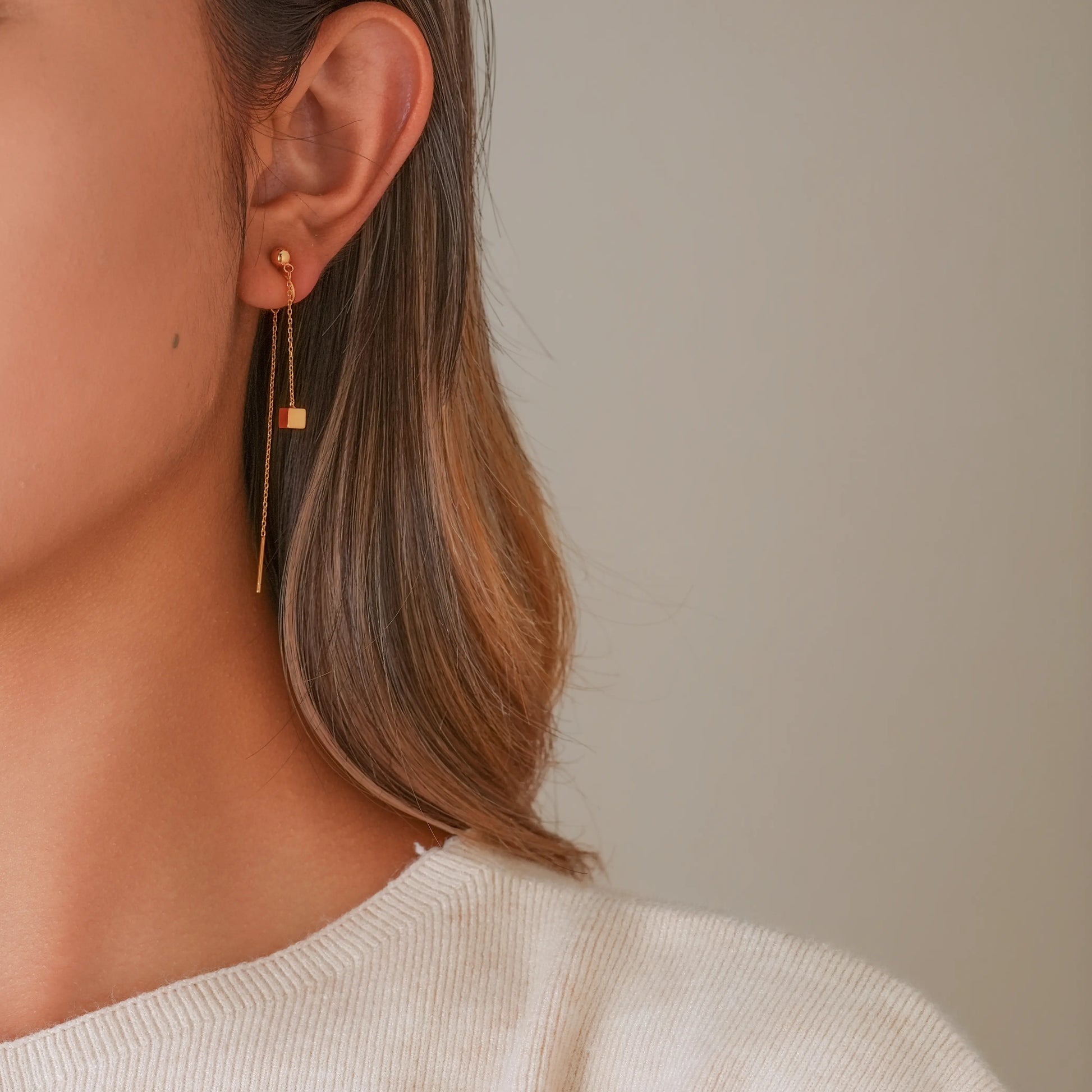 Model wearing gold threader illusion clips, showcasing a modern, elongated ear stack