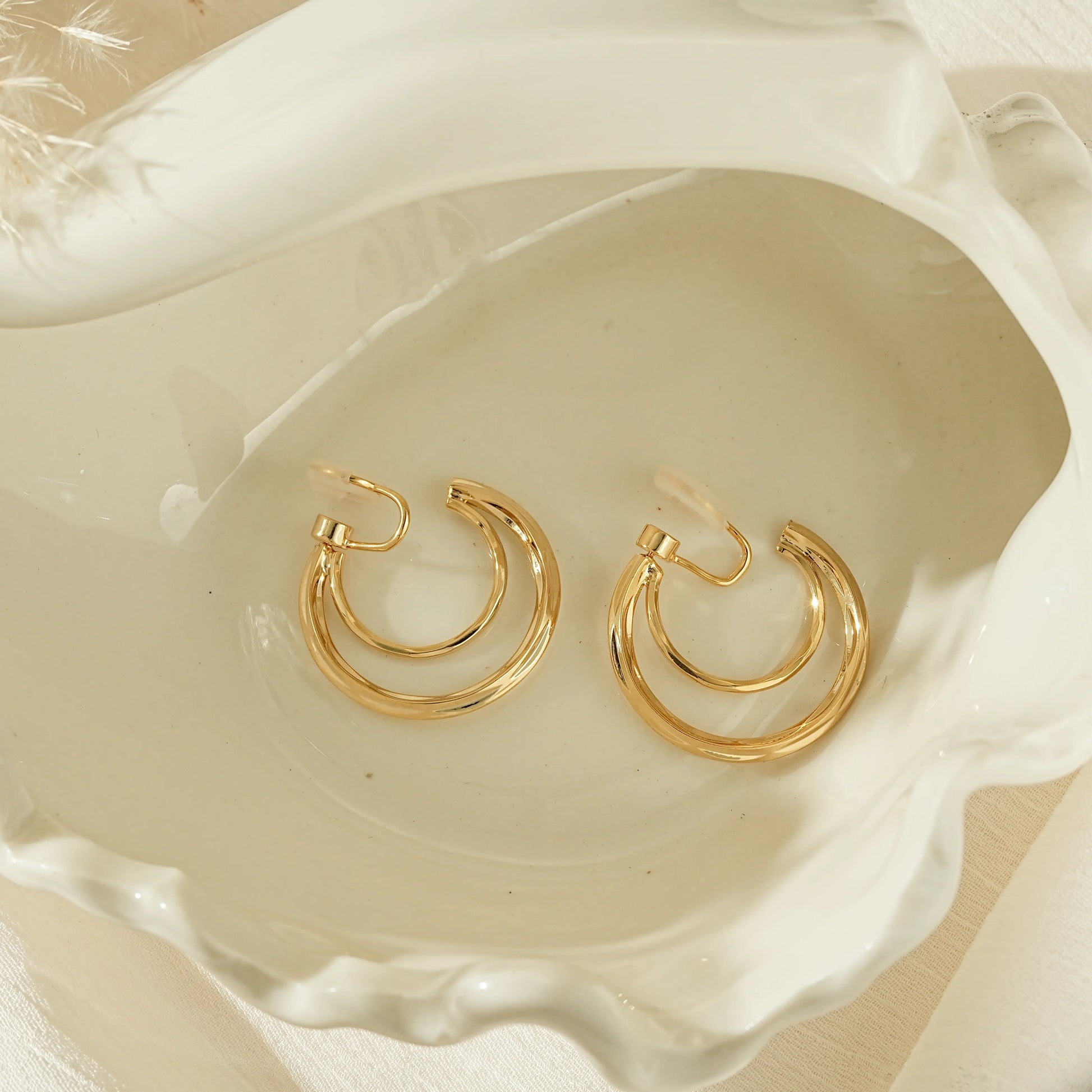 Close-up of 18k gold plated double hoops for unpierced ears, showing the high-shine finish.