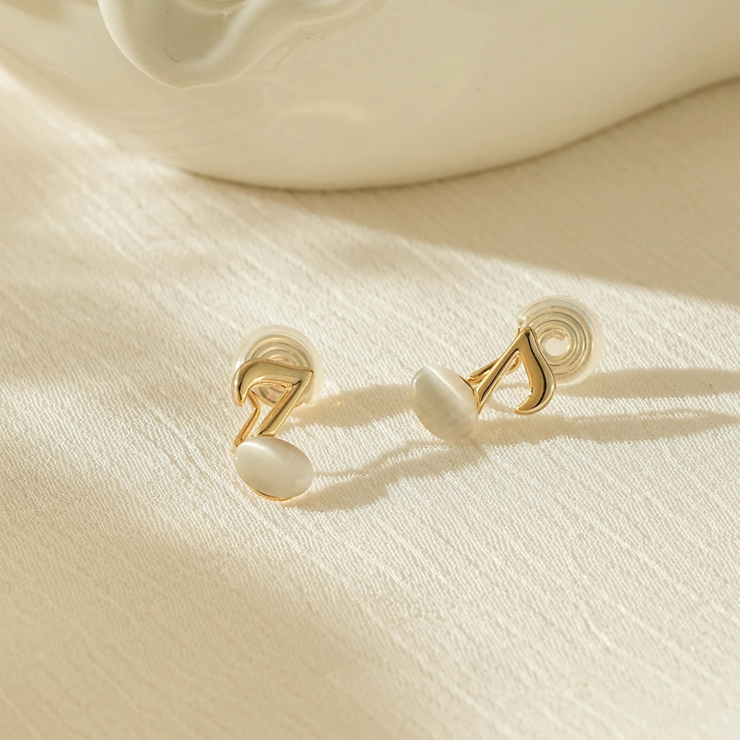 Gold music note clip-on earrings in 18k gold plating, eighth note design.