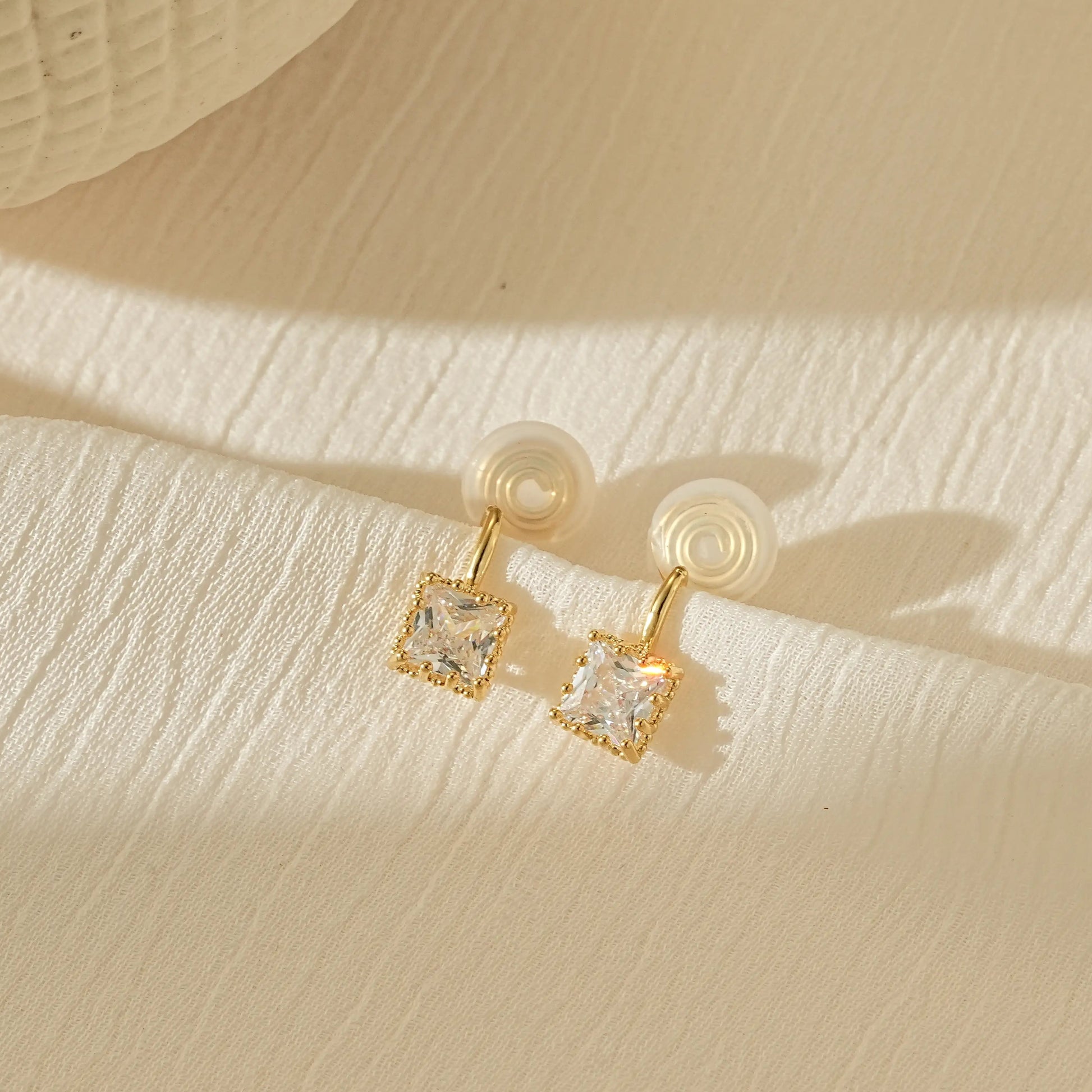 Macro close-up of the square princess cut CZ stone set in polished gold.