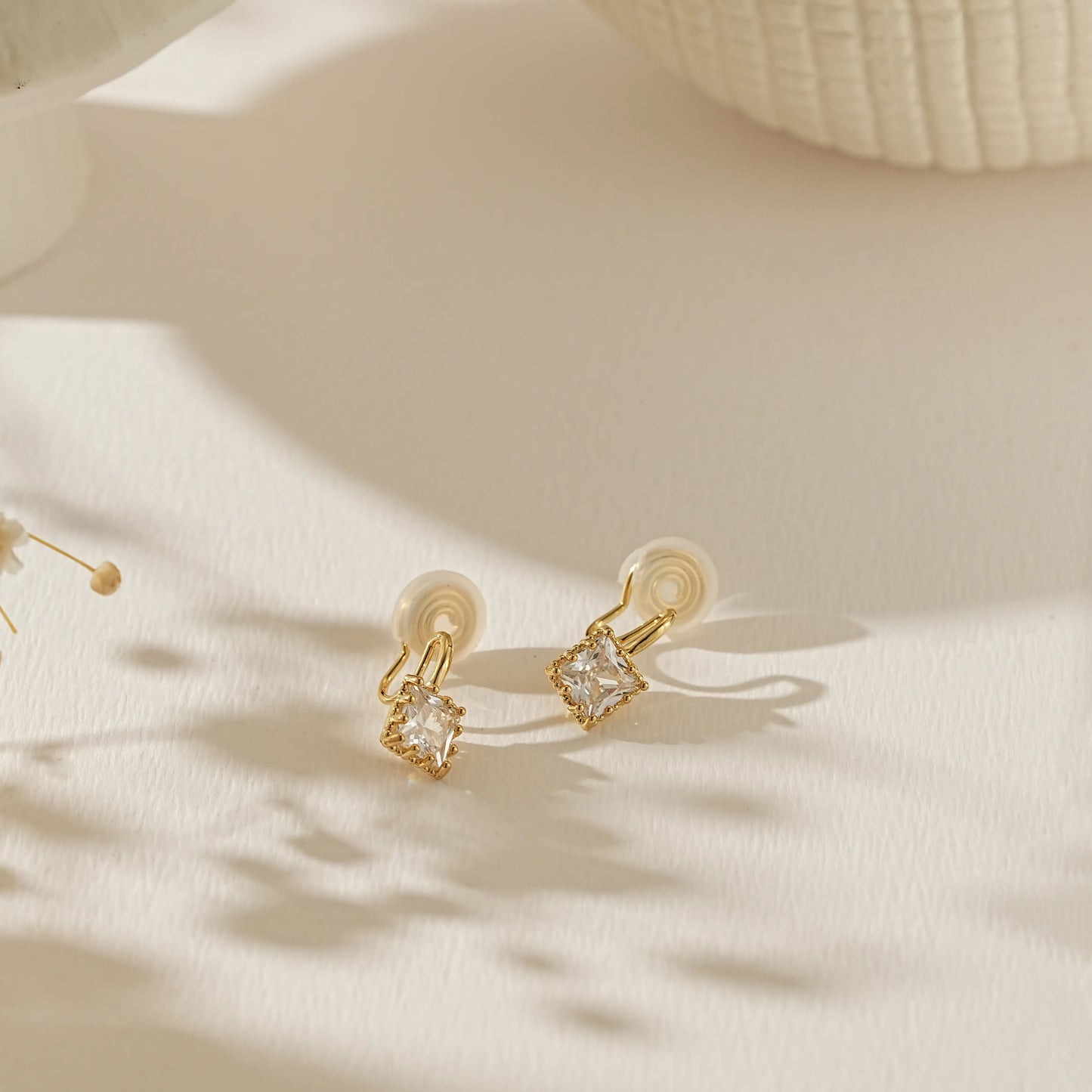 Side profile of 18k gold plated princess cut stud showing the adjustable clip-on mechanism for unpierced ears.