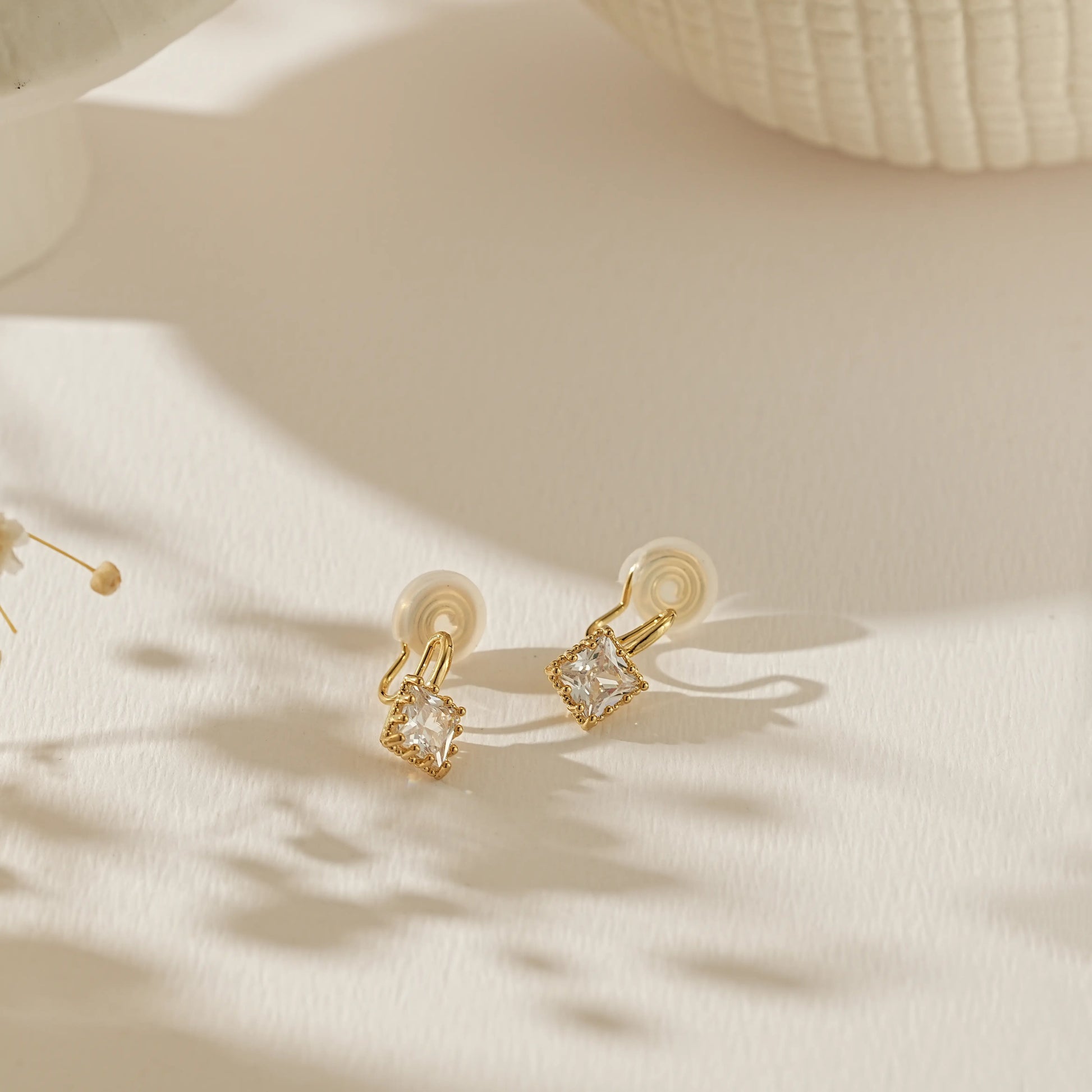 Side profile of 18k gold plated princess cut stud showing the adjustable clip-on mechanism for unpierced ears.