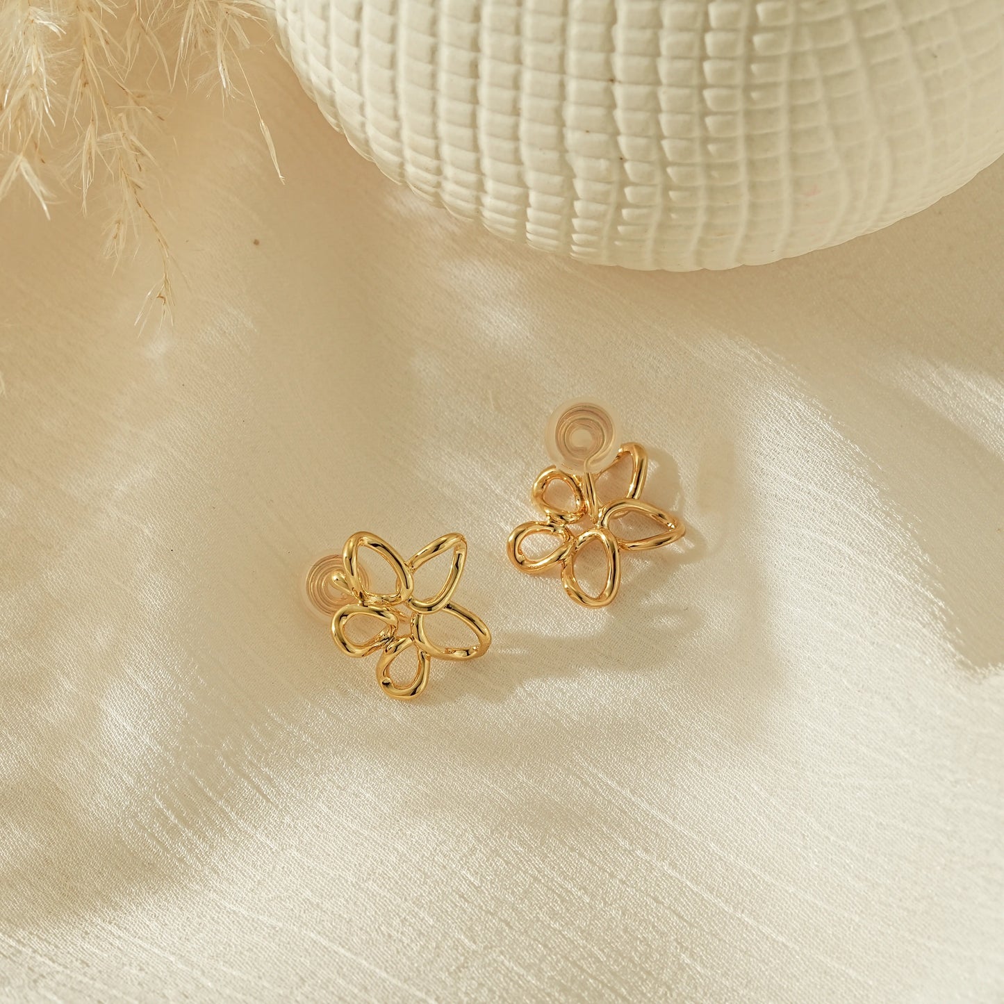Side view of gold wire flower clip-ons showing the adjustable pinch-free back.
