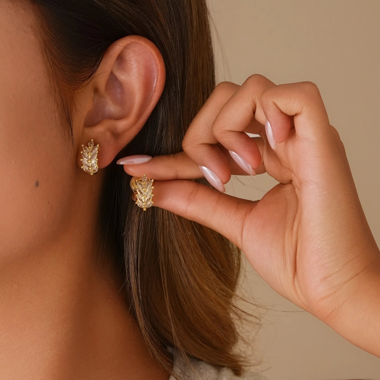 Close-up of model styling the wheat diamond earrings, showing the secure and comfortable fit.