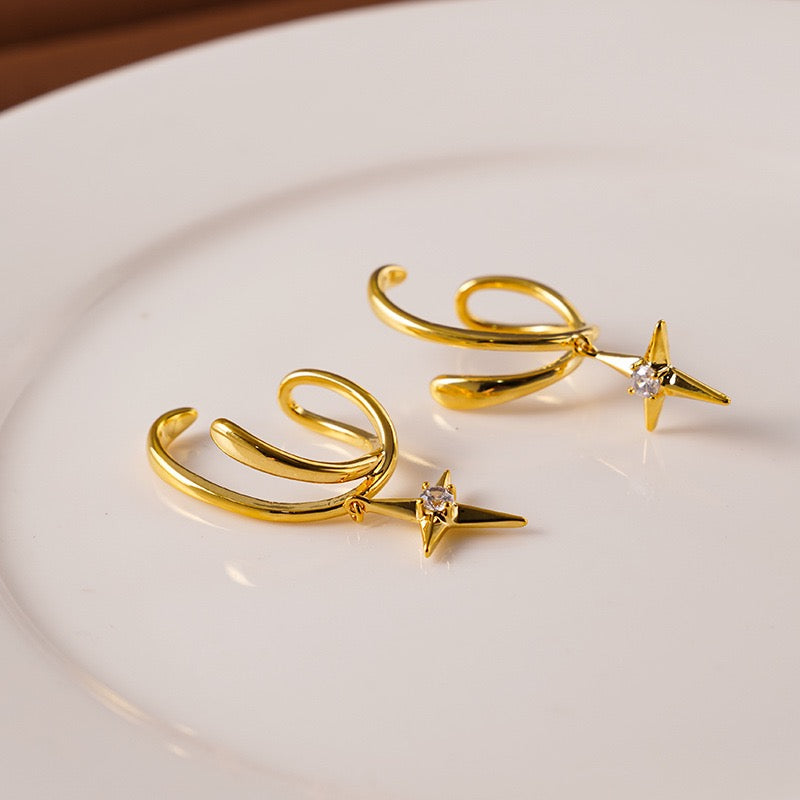 Model wearing a gold double hoop illusion clip-on earring with a North Star drop, demonstrating a seamless multi-pierced look on an unpierced ear.