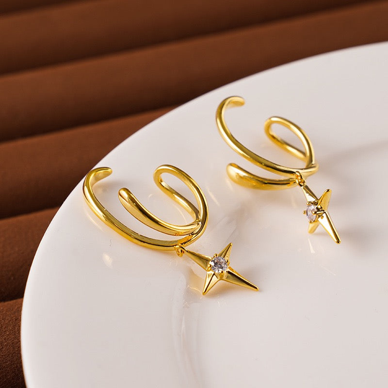 Close-up of the smooth wrap-around tension mechanism on a gold star drop illusion ear cuff.