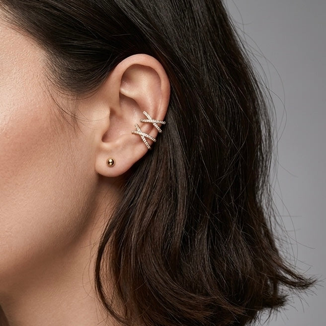 Side profile of a model wearing a gold pavé diamond cross ear cuff, showing it resting securely on the cartilage without a piercing