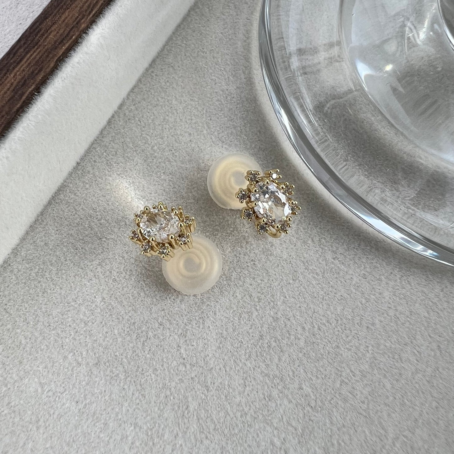 Angled macro shot of oval diamond stimulant studs capturing light reflection and facets
