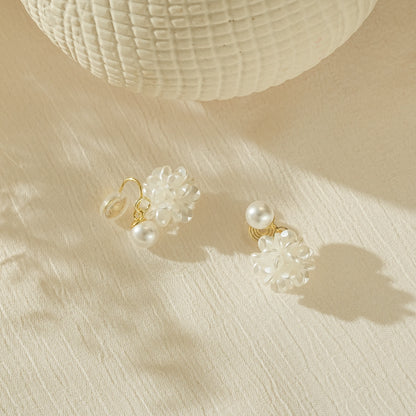 Close-up of the delicate white flower petals and lustrous pearl drop detail.