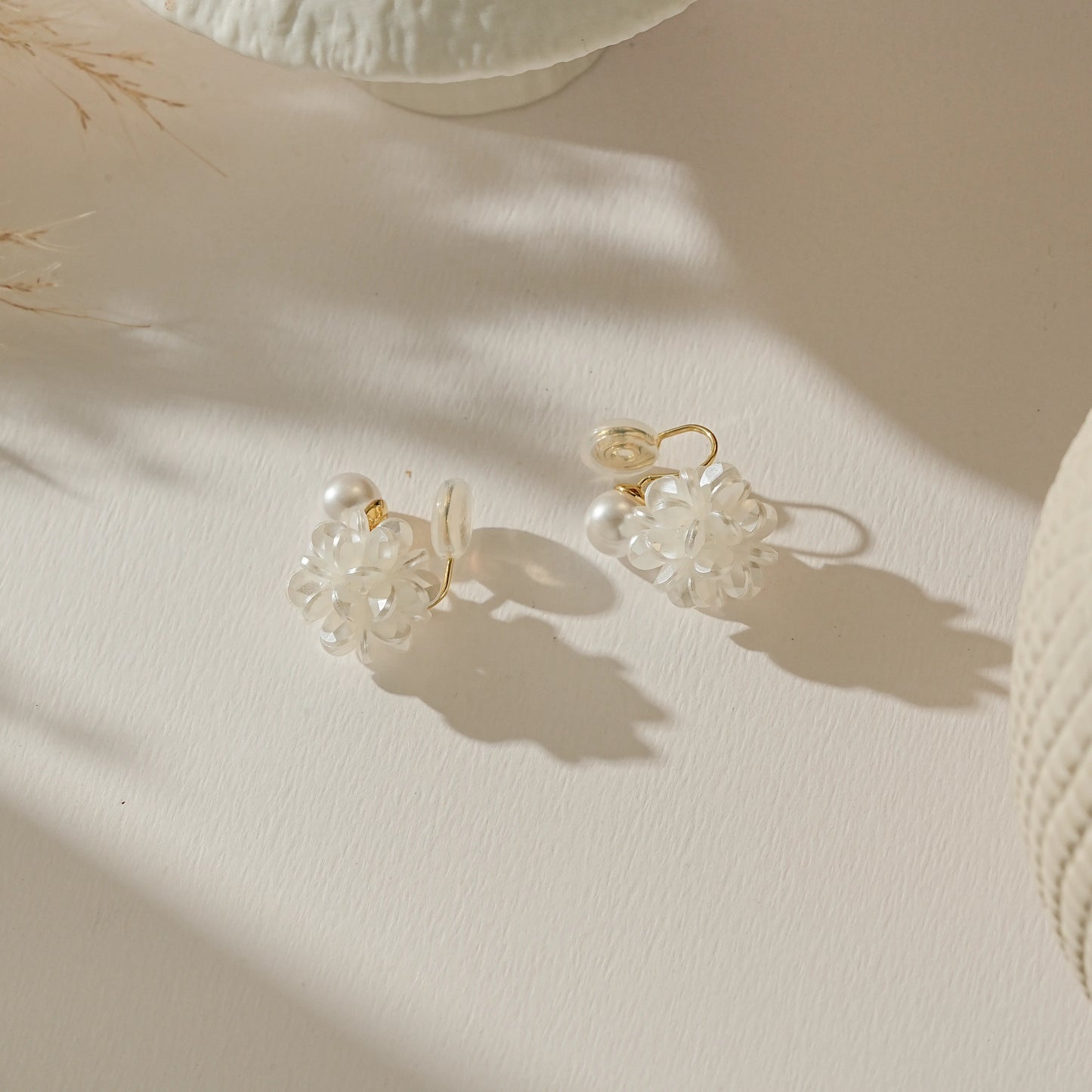 Elegant floral bridesmaid clip-on earrings laid on a soft white background.