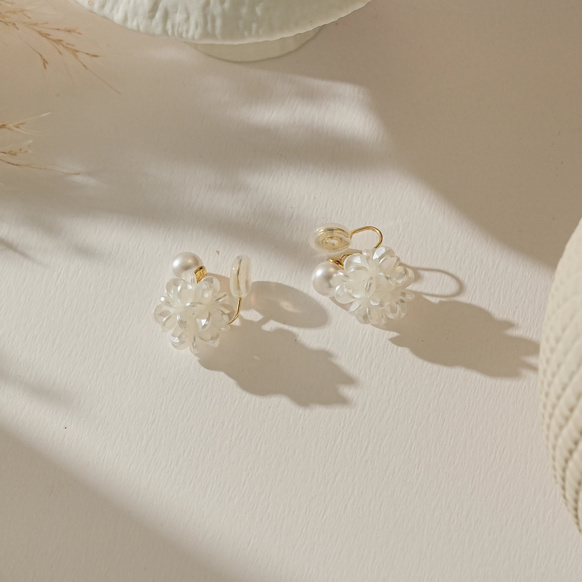 Elegant floral bridesmaid clip-on earrings laid on a soft white background.