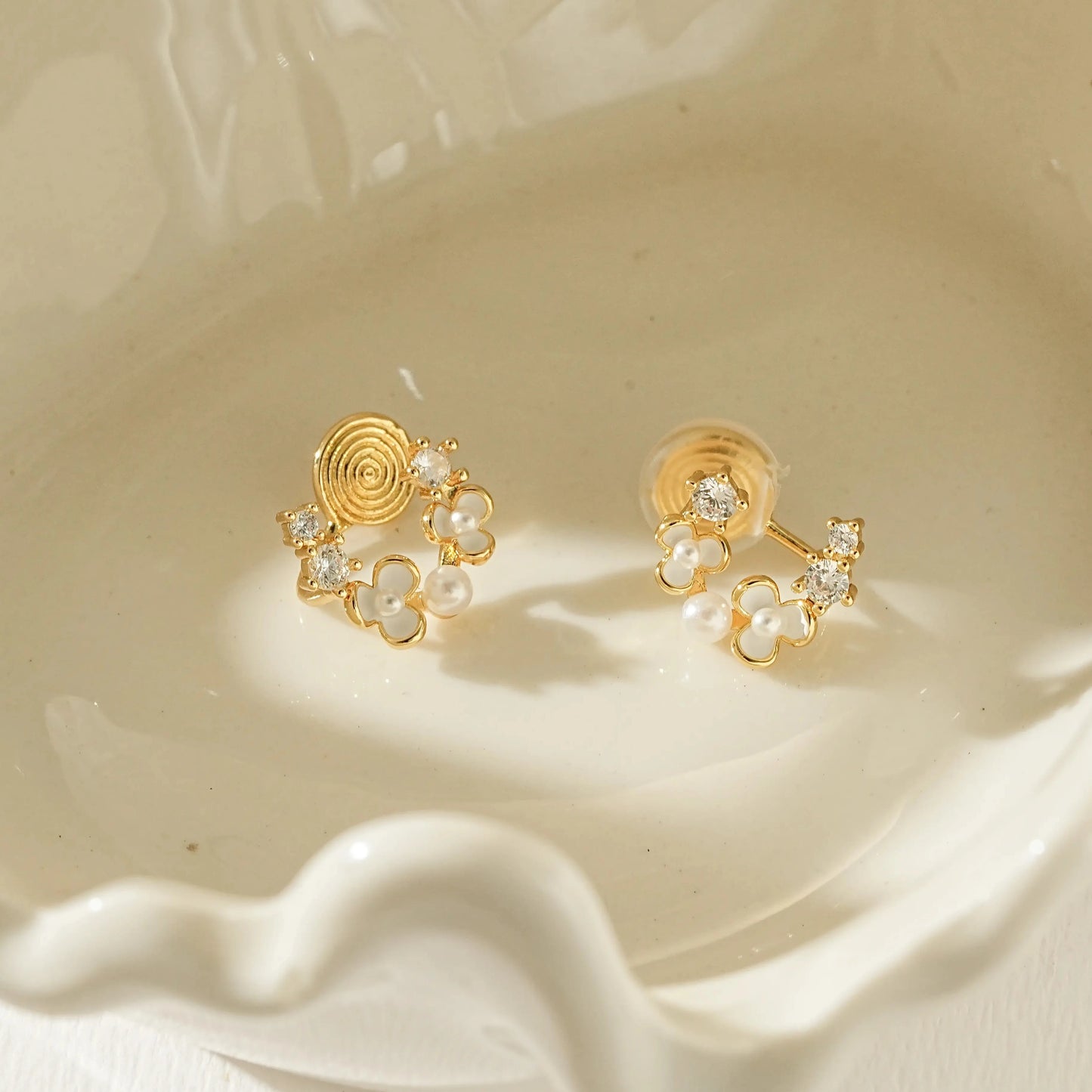 Close-up of the dainty gold flower petal and petite pearl center detail.