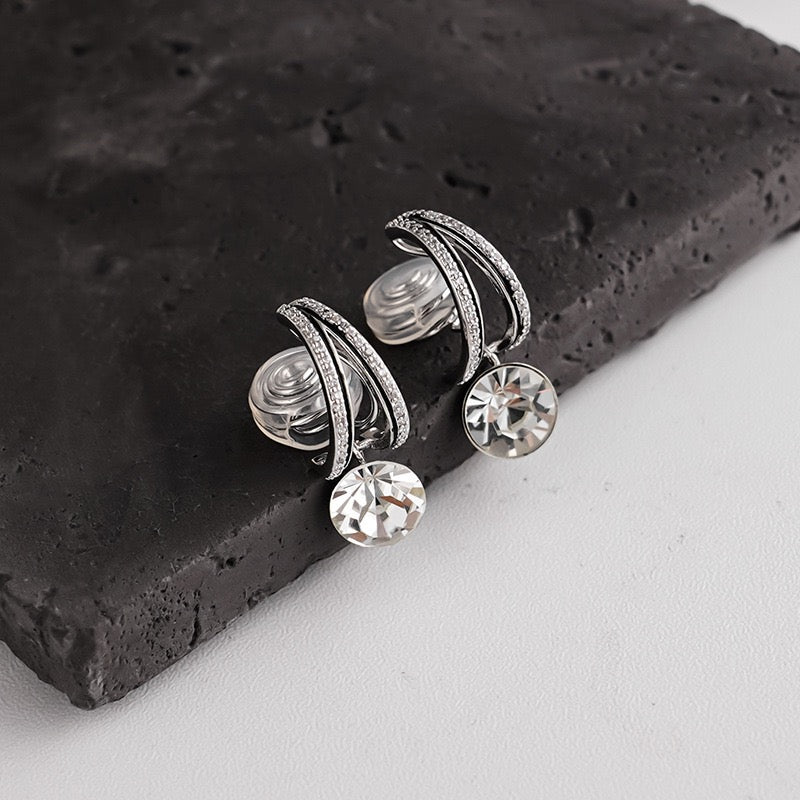 Detailed close-up showing the clear silicone cushion backing on a silver pave drop clip-on earring for comfortable wear.