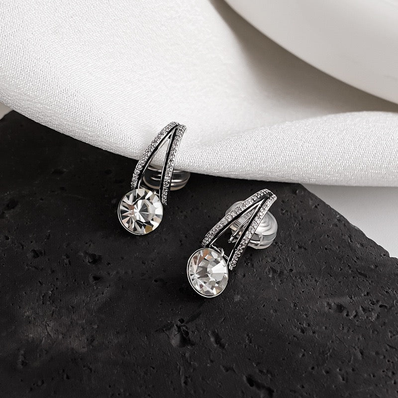 Silver diamond drop clip-on earrings displayed inside an Earclipse luxury velvet jewellery pouch