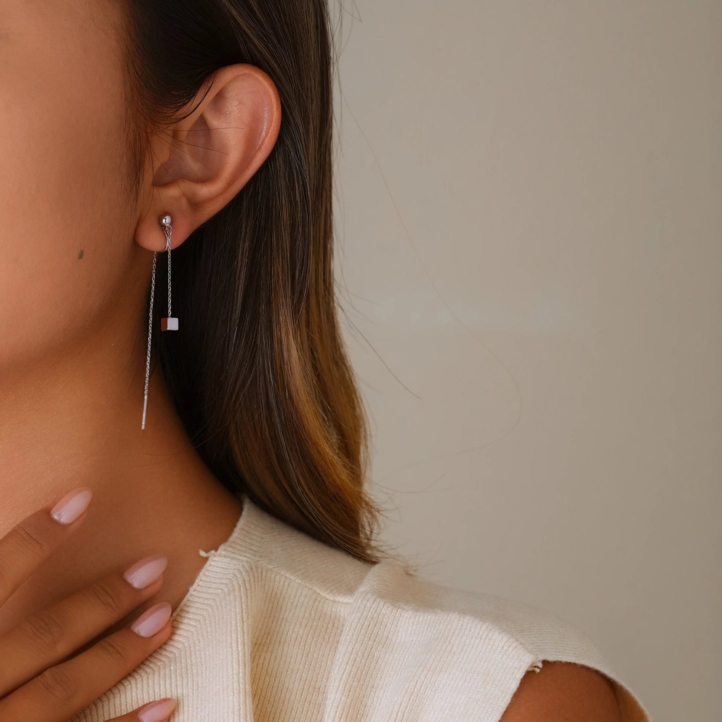 Model styling silver threader illusion earrings for a contemporary, edgy jewelry look.