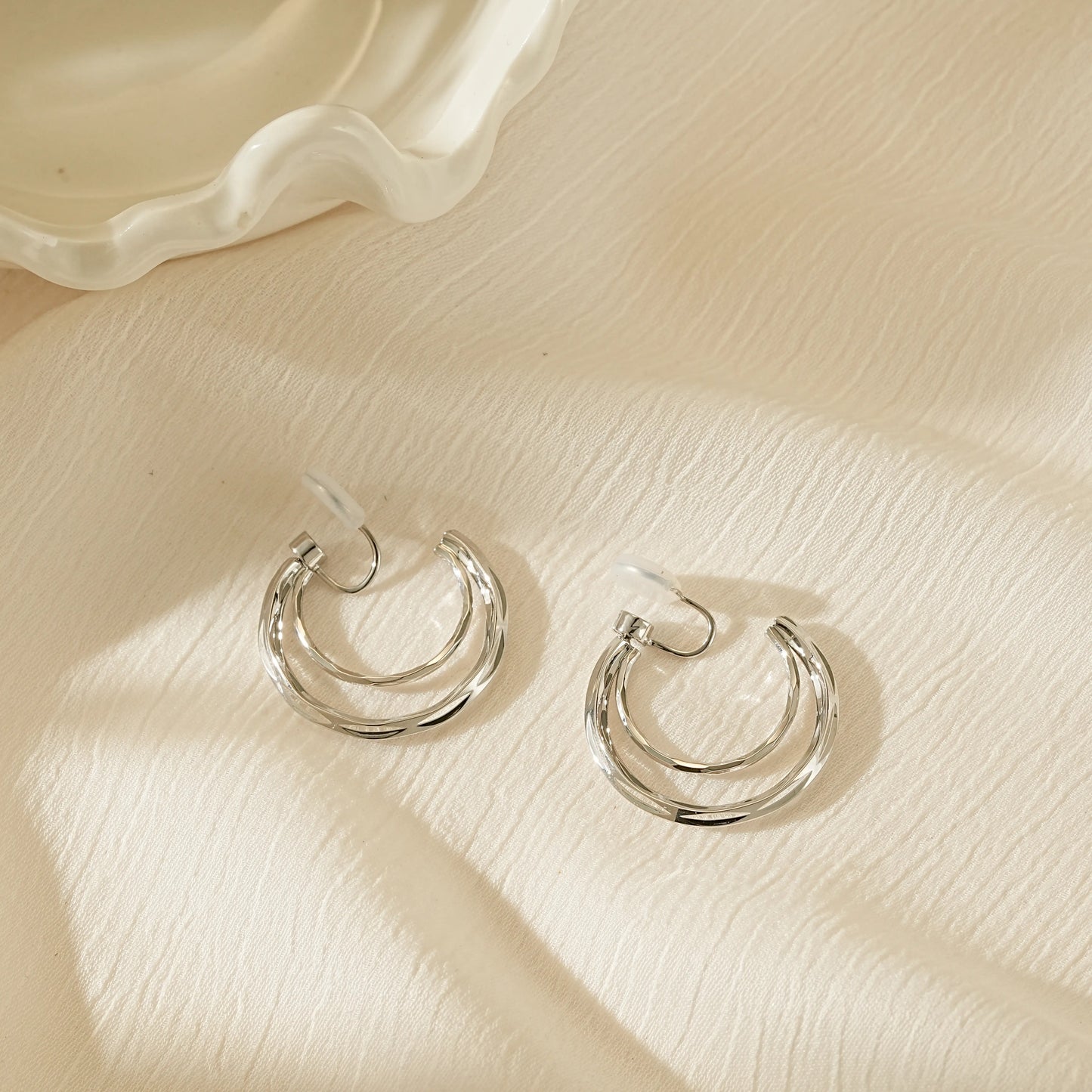 Side view of silver double hoops illustrating the lightweight, hollowed-out structure.
