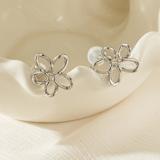 Close-up of the architectural silver wire floral silhouette on non-pierced earrings.