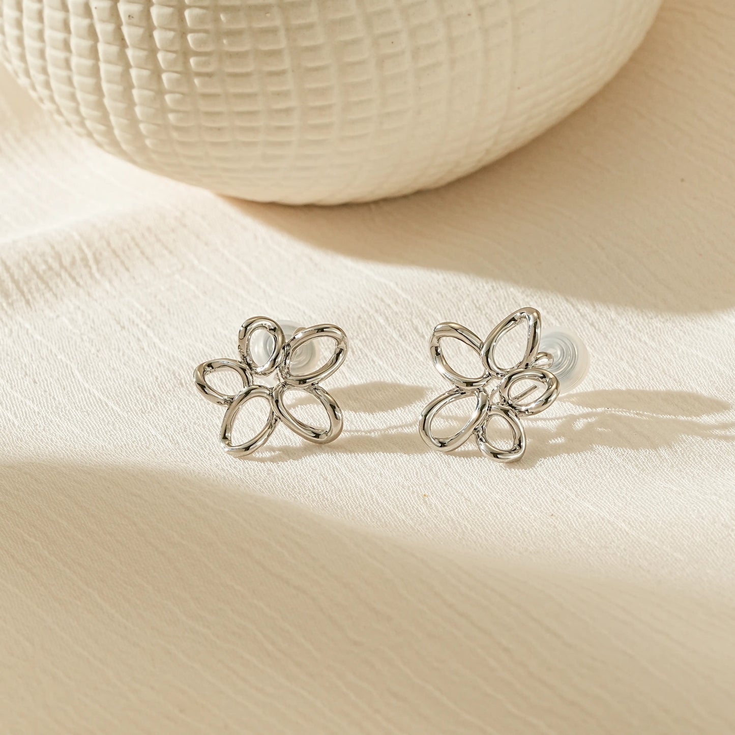 Polished silver twisted wire flower clip-on earrings for unpierced ears.