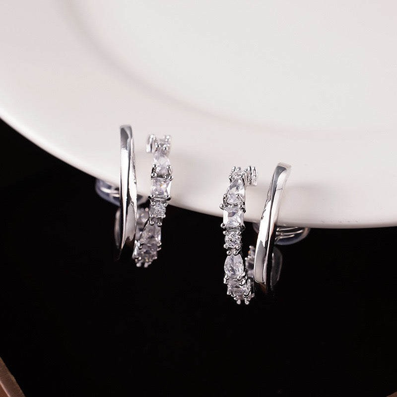 Detailed close-up showing the soft clear silicone comfort cushions on the wire clip backing of a silver crystal double hoop earring
