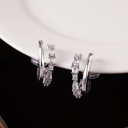 Detailed close-up showing the soft clear silicone comfort cushions on the wire clip backing of a silver crystal double hoop earring