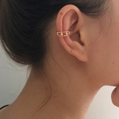 Model wearing the gold star double-band ear cuff on the upper cartilage, showing a secure, non-pierced fit.