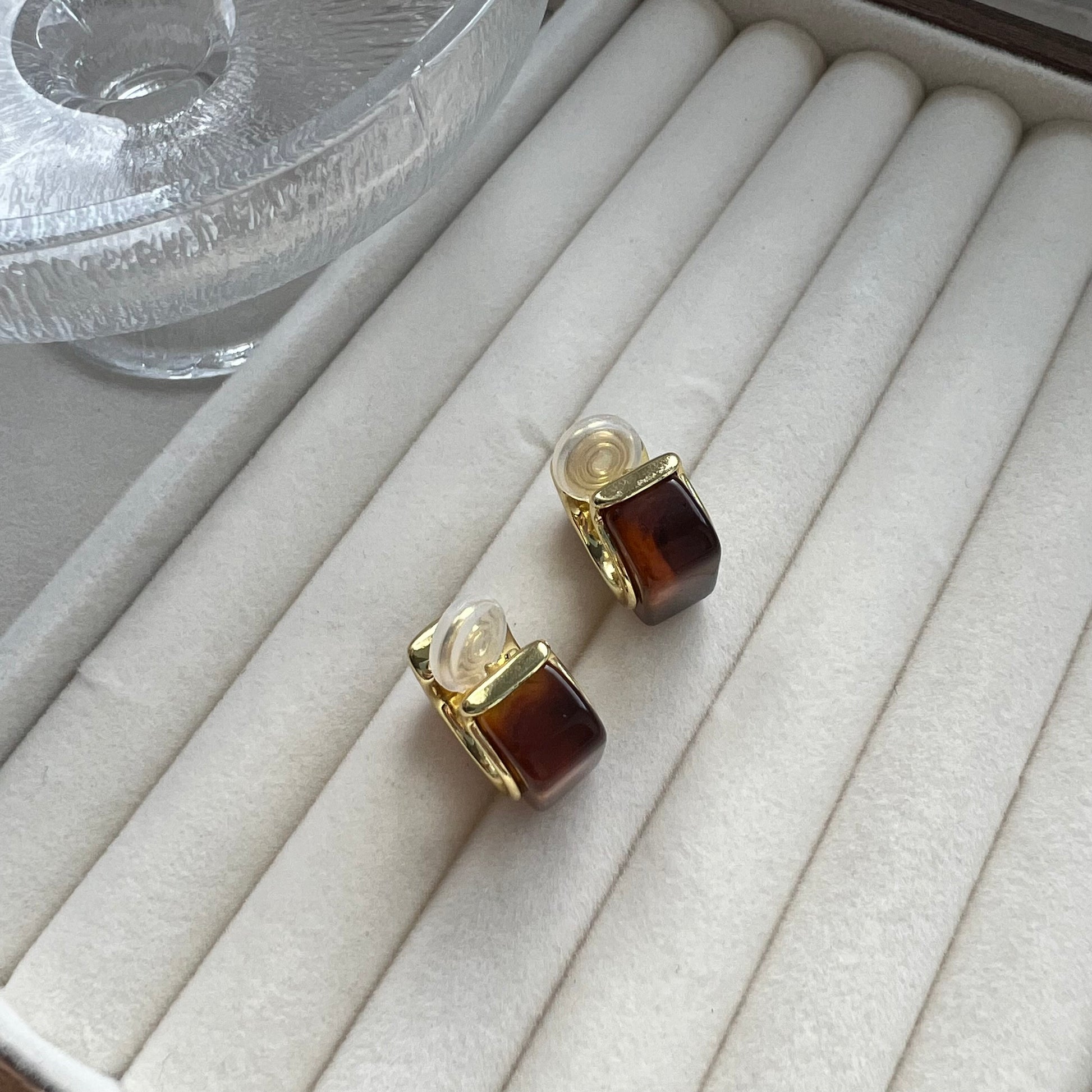 Pair of bold vintage-style gold hoop earrings with a rectangular amber stone setting. The earrings are shown on a neutral background. They feature a chunky, polished gold finish and a rich, honey-colored center stone.