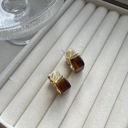 Pair of bold vintage-style gold hoop earrings with a rectangular amber stone setting. The earrings are shown on a neutral background. They feature a chunky, polished gold finish and a rich, honey-colored center stone.