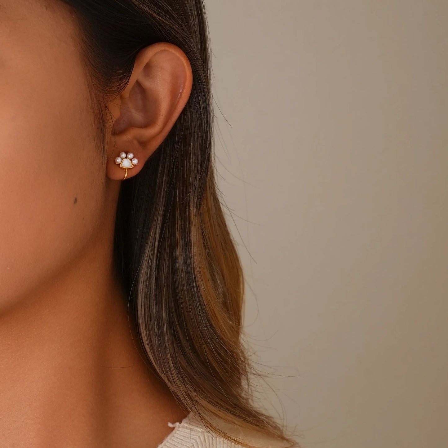 Model wearing the tiny paw print pearl gold earrings for a cute, everyday look.