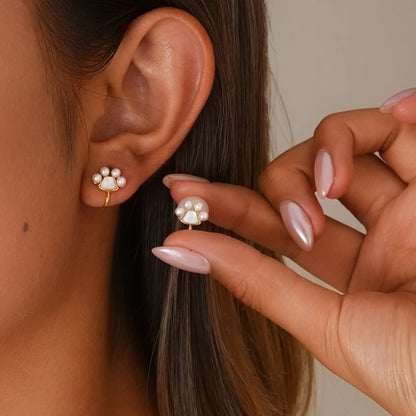 Close-up of model styling the paw print clip-ons, showing the realistic "pierced" fit.