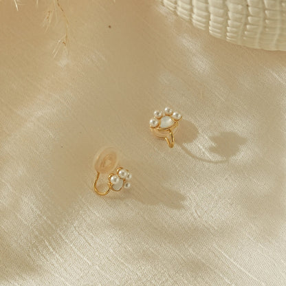Side view of the paw print pearl stud showing the adjustable, pinch-free clip.