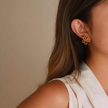 Model wearing gold twisted wire flower clip-ons for a modern, airy everyday look.