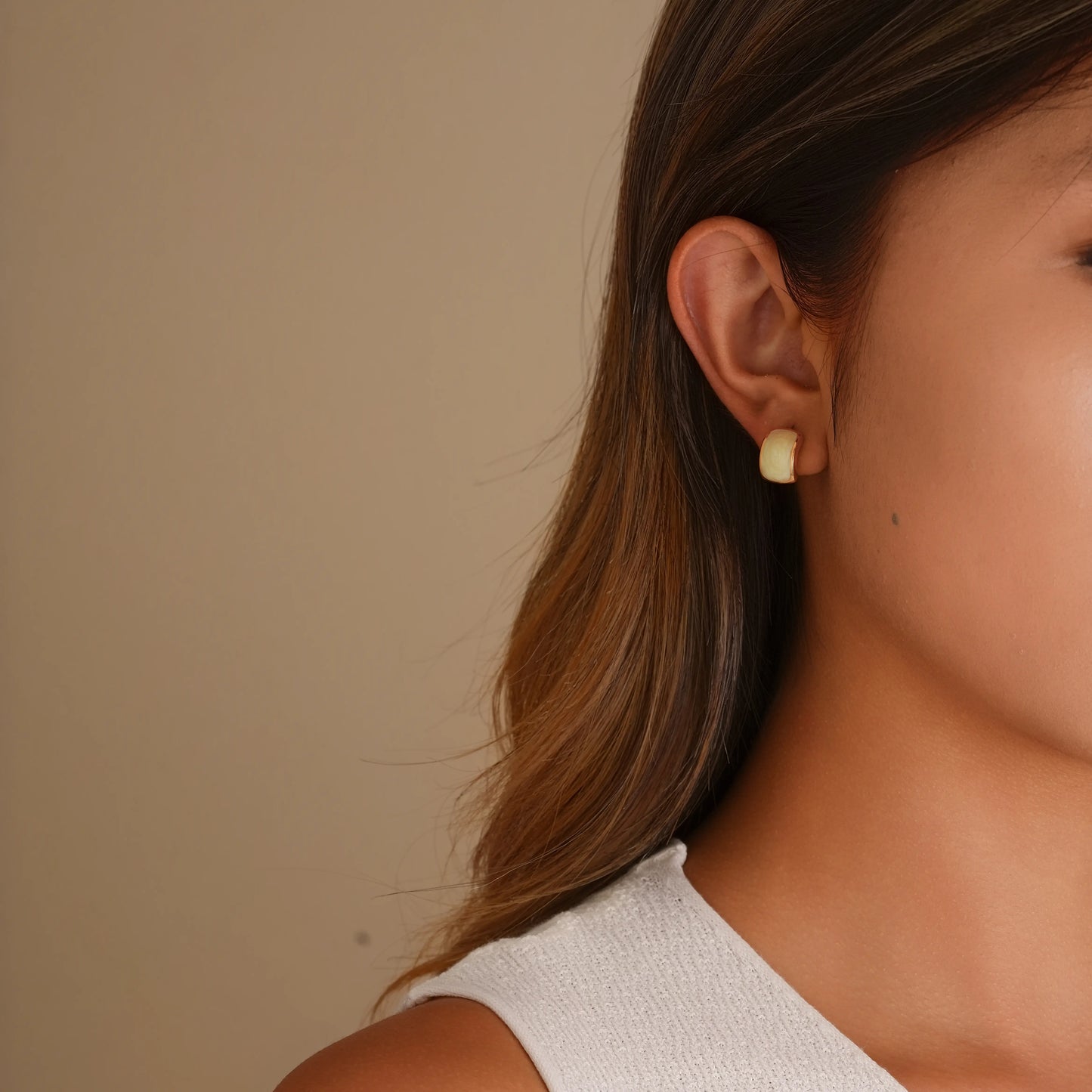 Model wearing the white enamel gold clip-ons for a modern, "clean girl" look.