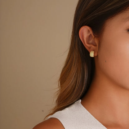 Model wearing the white enamel gold clip-ons for a modern, "clean girl" look.