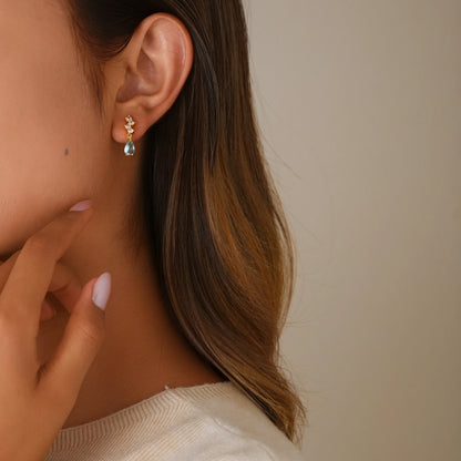 Model wearing Earclipse Boutique aquamarine drop clip-on earrings to demonstrate size, scale, and a secure fit on the earlobe.
