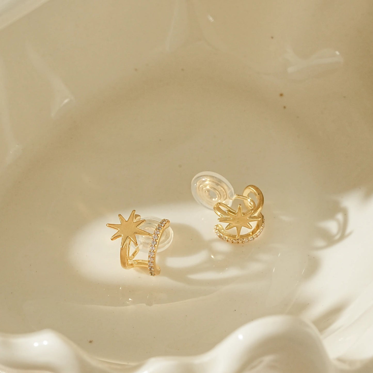 Close-up of adjustable gold star clip-on hoops for unpierced ears.