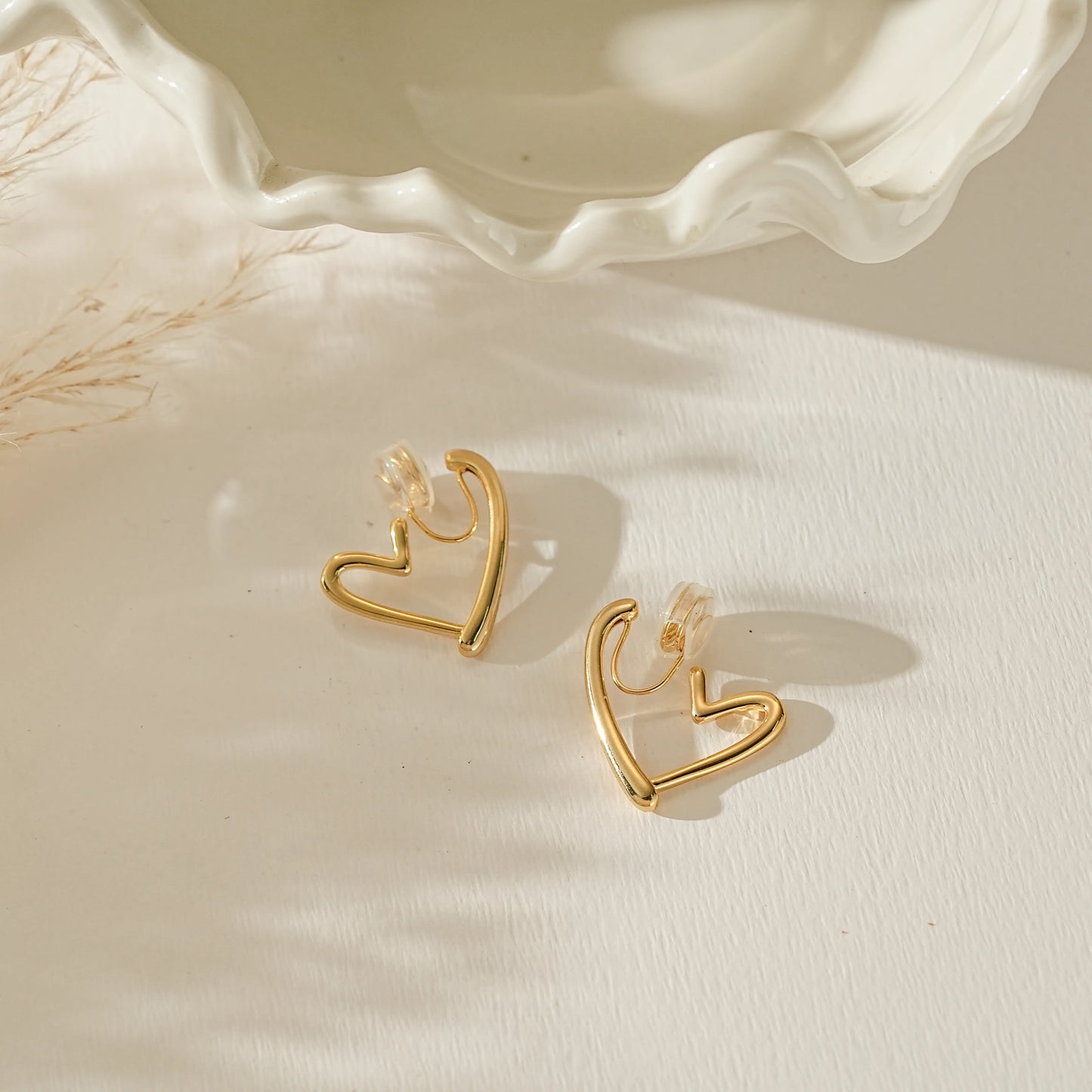 Side profile of gold heart hoop showing the adjustable clip-on mechanism and lightweight structure.