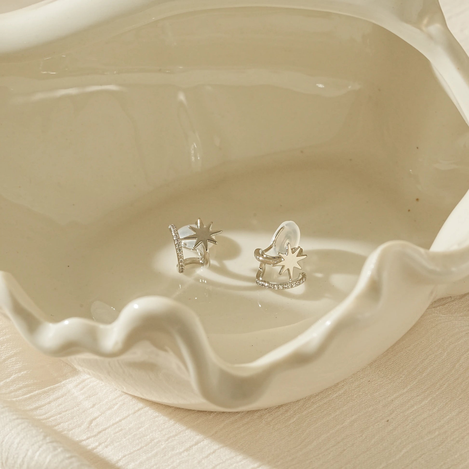 Polished silver double hoop star clip-on earrings for a non-pierced ear stack.